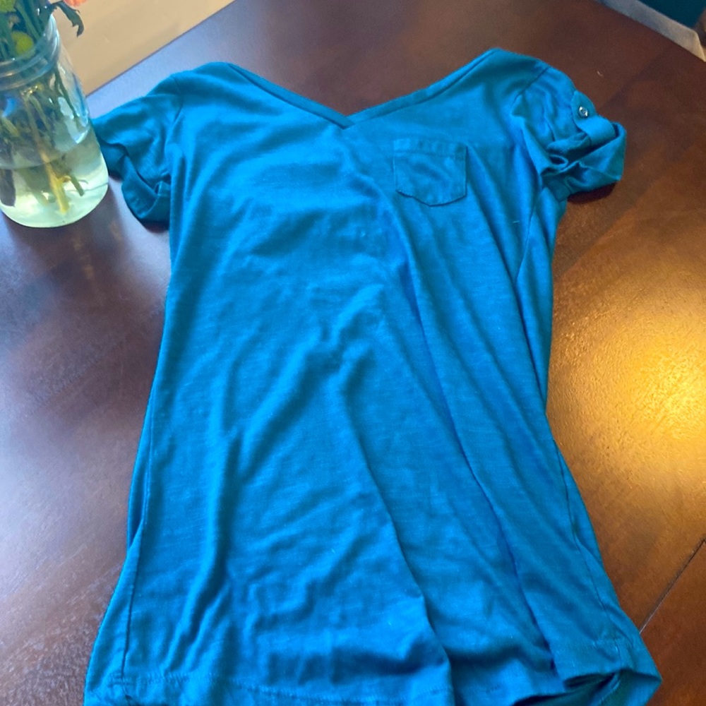 Blue shit with button sleeves, V-Neck and pocket.